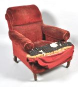 A Victorian armchair, in need of re-upholstery, with deep long seat on turned tapering fluted legs,