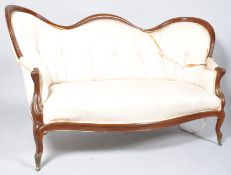 A Victorian mahogany show frame sofa with serpentine button back on cabriole legs with brass