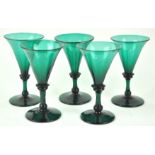 A set of five early 19th century green wine glasses, each with flared bowls,