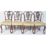 A set of four mahogany salon chairs with carved and pierced scroll splats and stuff over seats on