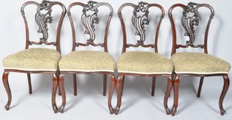 A set of four mahogany salon chairs with carved and pierced scroll splats and stuff over seats on