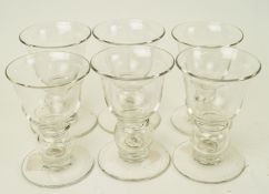 A group of six lead crystal port glasses with bell bowls and plain feet,