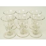 A group of six lead crystal port glasses with bell bowls and plain feet,