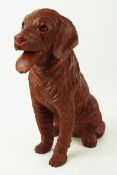 A carved wood figure of a seated labrador,