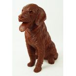 A carved wood figure of a seated labrador,