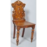 A Victorian oak hall chair with carved cartouche shaped back, solid seat and turned tapering legs,