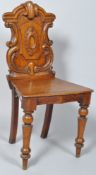A Victorian oak hall chair with carved cartouche shaped back, solid seat and turned tapering legs,