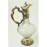 A cut glass claret jug with Rococo silver plated mounts, decorated with 'C' scrolls and flowers,