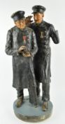 A patinated plaster figure of two vetran soldiers taking snuff,