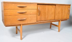 A 1960'S retro vintage teak wood sideboard credenza having three drawers adjacent to a twin