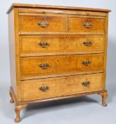 A walnut chest of two short and three long drawers, with brushing slide and carved cabriole legs,