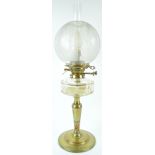 A late 19th century brass oil lamp with cut glass reservoir, chimney and etched globular shade,