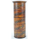 A cylindrical stacking treen spice box, with section labelled cloves, cinnamon, mace,