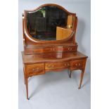 An Edwardian mahogany dressing table with shaped mirror,