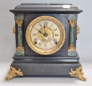 A Victorian mantel clock, in blackened marble, with lion mask handles,