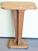 An oak rectangular section Art Deco style table, on tapering quatrefoil stem ad rectangular plinth,