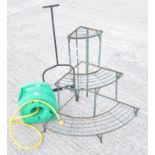 A metal plant stand and hose and boot scraper