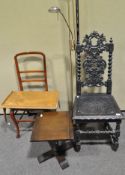 An ebonised hall chair with elaborately carved foliate back, 115cm high,