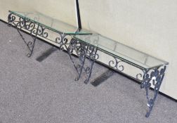 A pair of painted black metal wrought iron style occasional tables with glass tops,