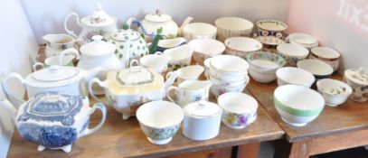 An assorted collection of ceramic tea wares, including seven pottery tea pots, milk jugs,