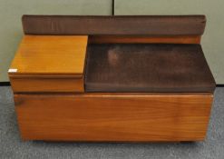 A 1970s telephone table, in teak, with a rectangular cushion,