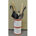 An Italian ceramic stick stand with a collection of umbrellas, a litter grab and other items,