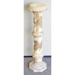A carved composite stone and resin plant stand, of spiral form, cared with stiff leaves,