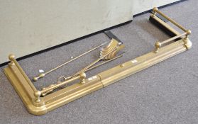 A large brass fender and four fire tools, the fender with gallery,