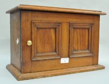 A smoker's cabinet, in hardwood, with double panel doors set a brass knob, 26cm high x 40.