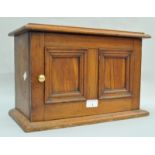 A smoker's cabinet, in hardwood, with double panel doors set a brass knob, 26cm high x 40.