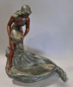 A metal Art Nouveau style sculpture of a maiden water carrier, her drape forming a well,