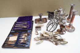 A collection of silver plate and flatware, including a pair of candlesticks,