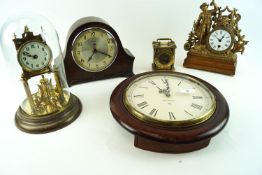 An 11 inch high brass torsion clock under a glass dome,