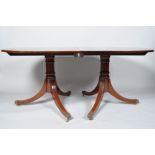 A 20th century mahogany twin pedestal oval dining table with two leaves and runners