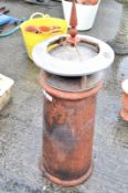 A terracotta chimney pot with a zinc cowl