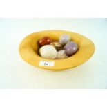 A turned horse chestnut wood bowl with nine decorative mixed mineral eggs