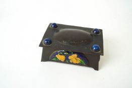 An Arts and Crafts copper box set with enamel panels decorated with flowers,