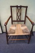 A Victorian oak and rush seat elbow chair