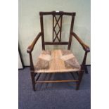 A Victorian oak and rush seat elbow chair