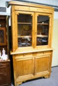 A pine dresser with glazed cupboard top