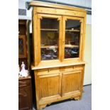 A pine dresser with glazed cupboard top