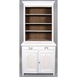 A white painted kitchen dresser with four shelves above two drawers above two carved cupboard doors,