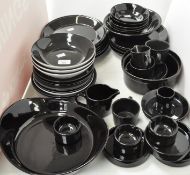 A collection of assorted black plates, cups and more,