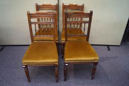 A set of four Victorian oak dining chairs with spindle gallery bar rest, cushioned seat ,
