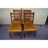 A set of four Victorian oak dining chairs with spindle gallery bar rest, cushioned seat ,