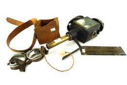 A mixed collection, including an antique car lamp, motorcycle goggles,