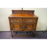 A small oak sideboard with two drawers above two cupboard doors