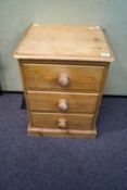 A pine bedside chest of three drawers