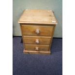 A pine bedside chest of three drawers