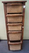 A 2oth century teak wood and wicker drawer unit with five wicker basket drawers of graduating sizes
